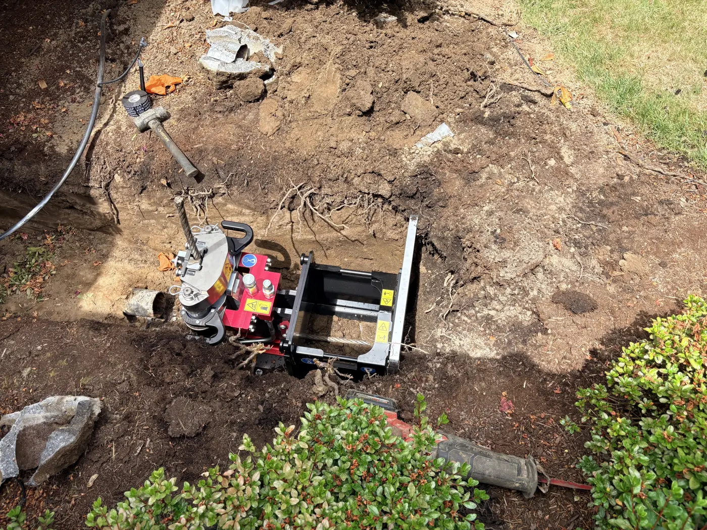 Bluetech trenchless pulling machine staged in the launch pit with cable rigged, ready to pull a new water service line